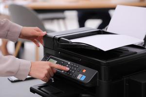 Employee using modern printer in office, closeup