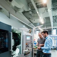 two male professionals inspecting machine