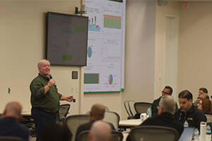 Instructor presenting a training session to a group of professionals in a classroom setting.