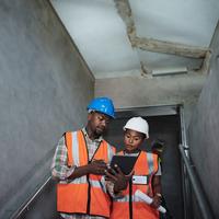 male and female wearing orange vest using digital tablet