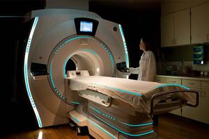 a healthcare professional standing beside an MRI machine